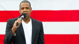 Jay-Z in front of an American flag