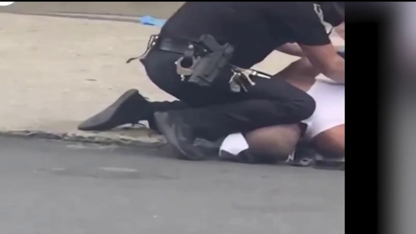 An Allentown police officer apparently kneels on a grounded man's head or neck.