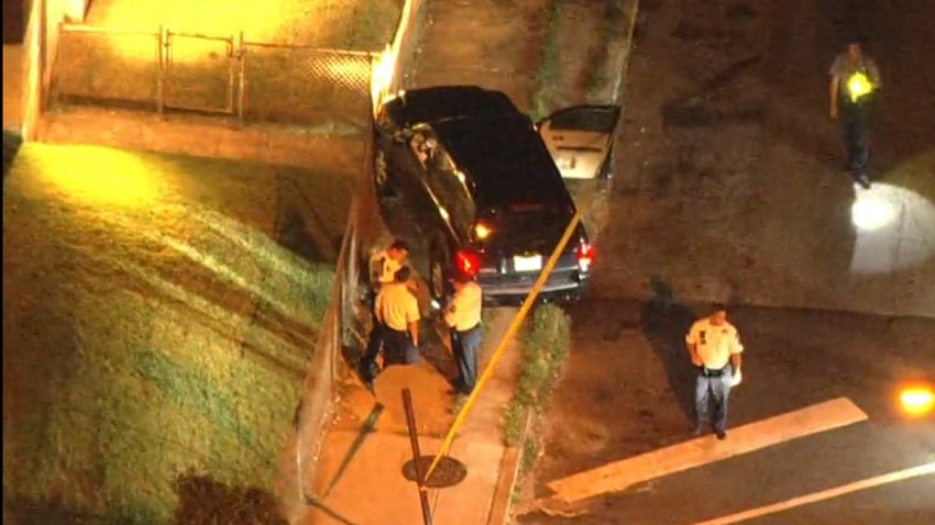 Investigators shine flashlights as they investigate a crash and gun battle after three Philadelphia police officers were ambushed.