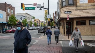 Pedestrians wearing protective masks walk through the Ironbound district of Newark, New Jersey
