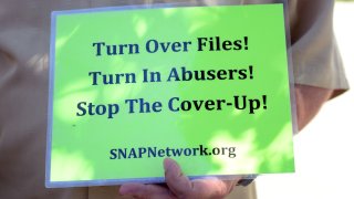 Someone holds up a sign for SNAPNetwork.org