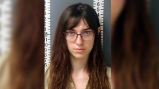 Riley June Williams, accused of stealing Democratic Rep. Nancy Pelosi's laptop during a riot at the Capitol, wears glasses as she looks at the camera in a police mug shot.