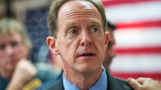 Sen. Pat Toomey, R-Pa., in front of a red white and blue background