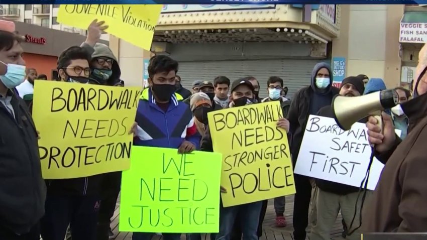 Atlantic City business owners hold up signs reading "We need justice" and similar slogans after another business owner died following a robbery by a group of kids.