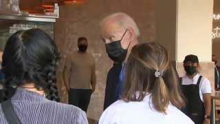 President Joe Biden speaks a woman from Philadelphia at a Washington, D.C., restaurant