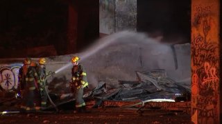 Firefighters douse water on a blaze at an interstate underpass in South Philadelphia.