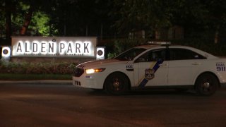 A Philadelphia police cruiser parks in front of a sign reading "Alden Park."