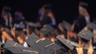College graduation caps are seen atop people's heads from behind
