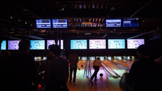 people bowling in a darkened room