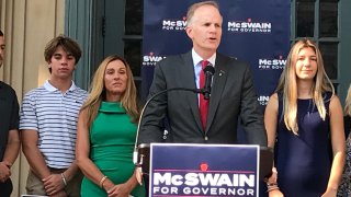 Former U.S. Attorney William McSwain, center, stands at a podium.