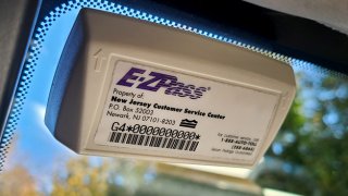 A New Jersey E-ZPass transponder placed on a windshield.