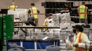Workers at the Pennsylvania Convention Center in Philadelphia sort through boxes of mail-in ballots during the 2020 presidential election.