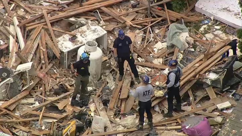 An aerial view shows investigators standing among the rubble following a house explosion that left five people dead in Pottstown, Pennsylvania.