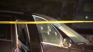 Bullet holes in a car window with yellow police tape in front