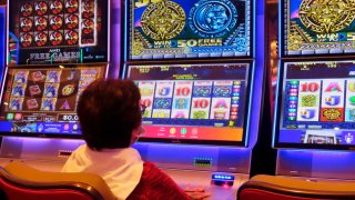 Person sits at colorful slot machine