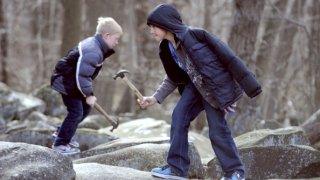 Two boys hold their hammers to make music at Ringing Rocks Park