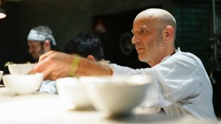 Marc Vetri preparing bowls of food under a kitchen light