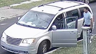 Man stands next to a silver minivan with the driver's side door open