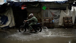 motociclista atraviesa una inundación