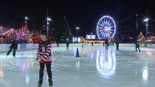 ice skater in front of lit up Ferris wheel