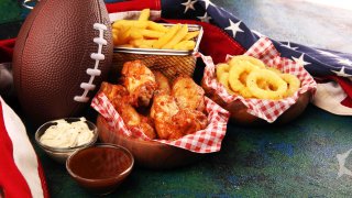 Comida típica consumida durante el Super Bowl como alitas de pollo, papas fritas y aros de cebolla.