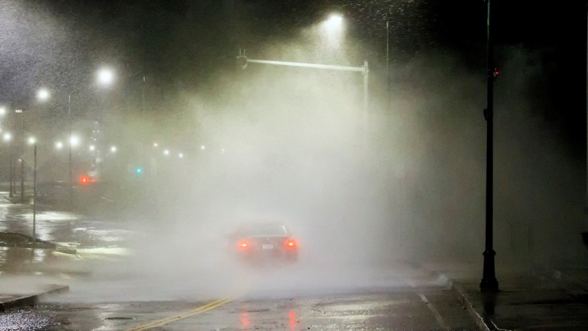 A car drives through a nor'easter in Winthrop, Massachusetts, on Tuesday, March 14, 2023.