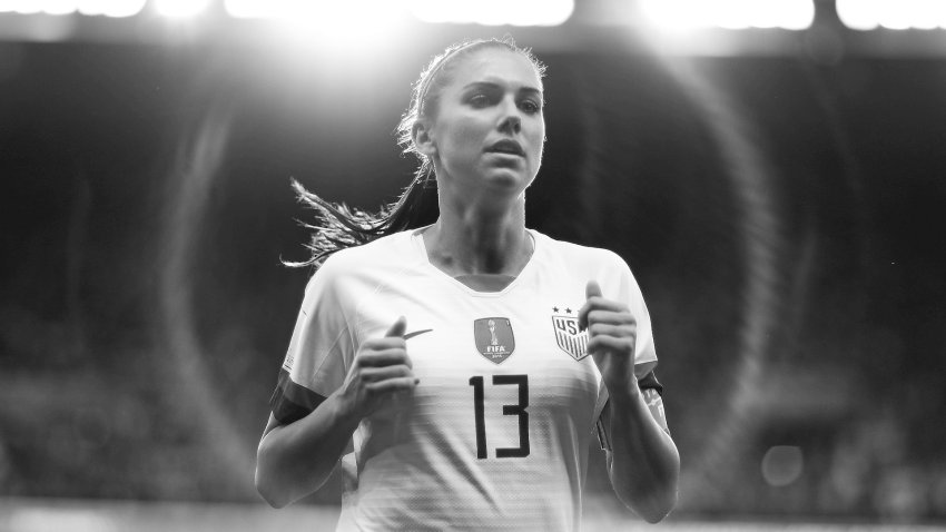 Alex Morgan corriendo en el campo.