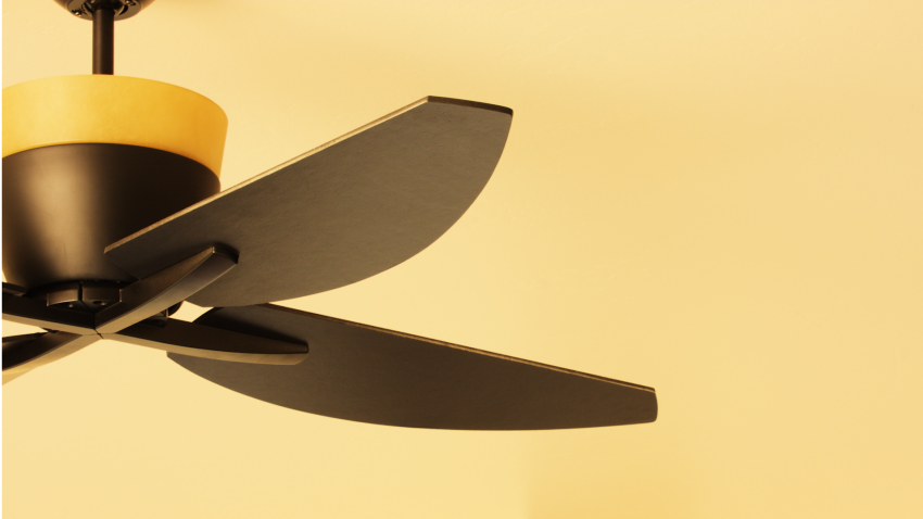 Ceiling fan against yellow ceiling