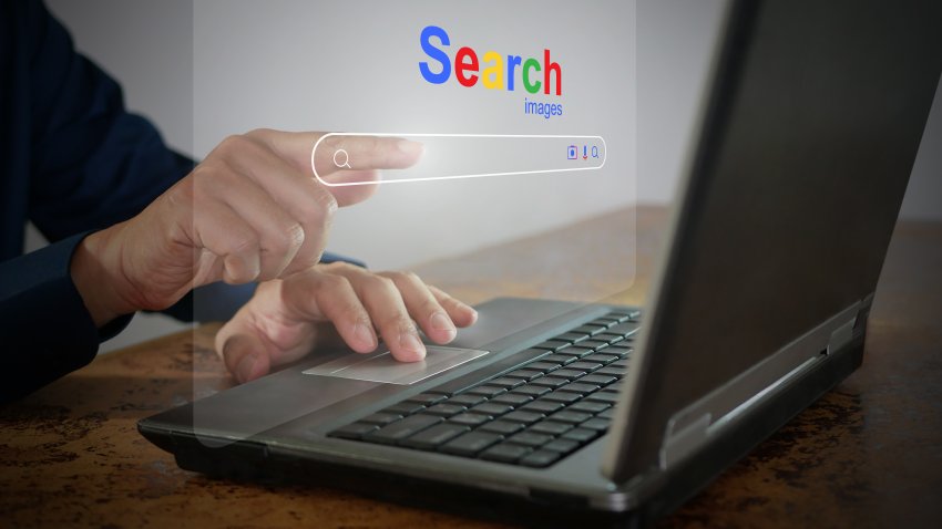 A man is using a notebook computer to searching for information. A virtual screen of the Search website browser for finding data on the internet. Global network, search engine optimization technology