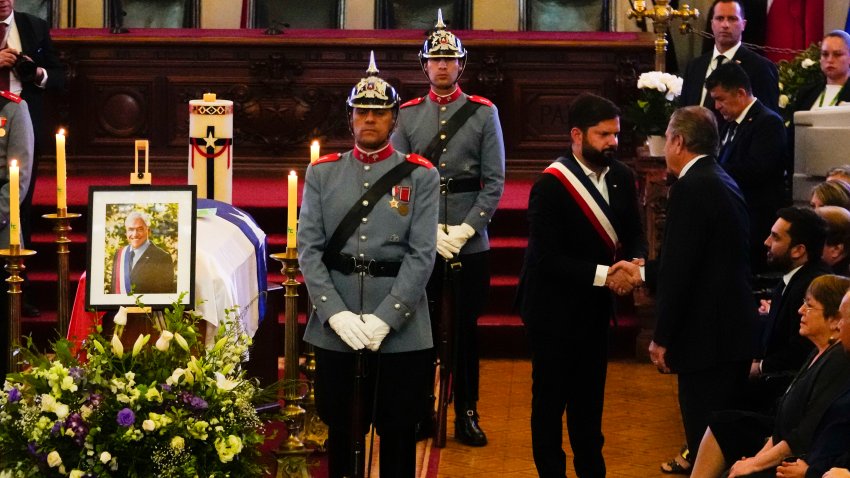 El presidente de Chile, Gabriel Boric, en el centro, le da la mano al exmandatario chileno Eduardo Frei junto al ataúd del fallecido presidente chileno Sebastián Piñera durante su velorio en el Congreso en Santiago, Chile, el viernes 9 de febrero de 2024. El dos veces expresidente murió el 6 de febrero en un accidente de helicóptero. Tenía 74 años. (AP Foto/Esteban Félix)