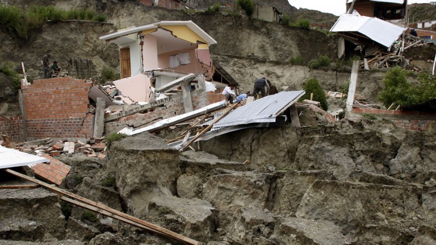 TOPSHOT – View of the remains of a house in Alpacoma valley in La Paz, 23 January, 2008 after heavy rains caused a landslide that devastated 11 houses. The Bolivian government decreed on Tuesday a national emergency to counteract damages caused by heavy rains and floods battering the country since last November. According to official sources, 22 people died so far and about 20,000 families have been damaged.   AFP PHOTO/AIZAR RALDES (Photo by AIZAR RALDES / AFP) (Photo by AIZAR RALDES/AFP via Getty Images)