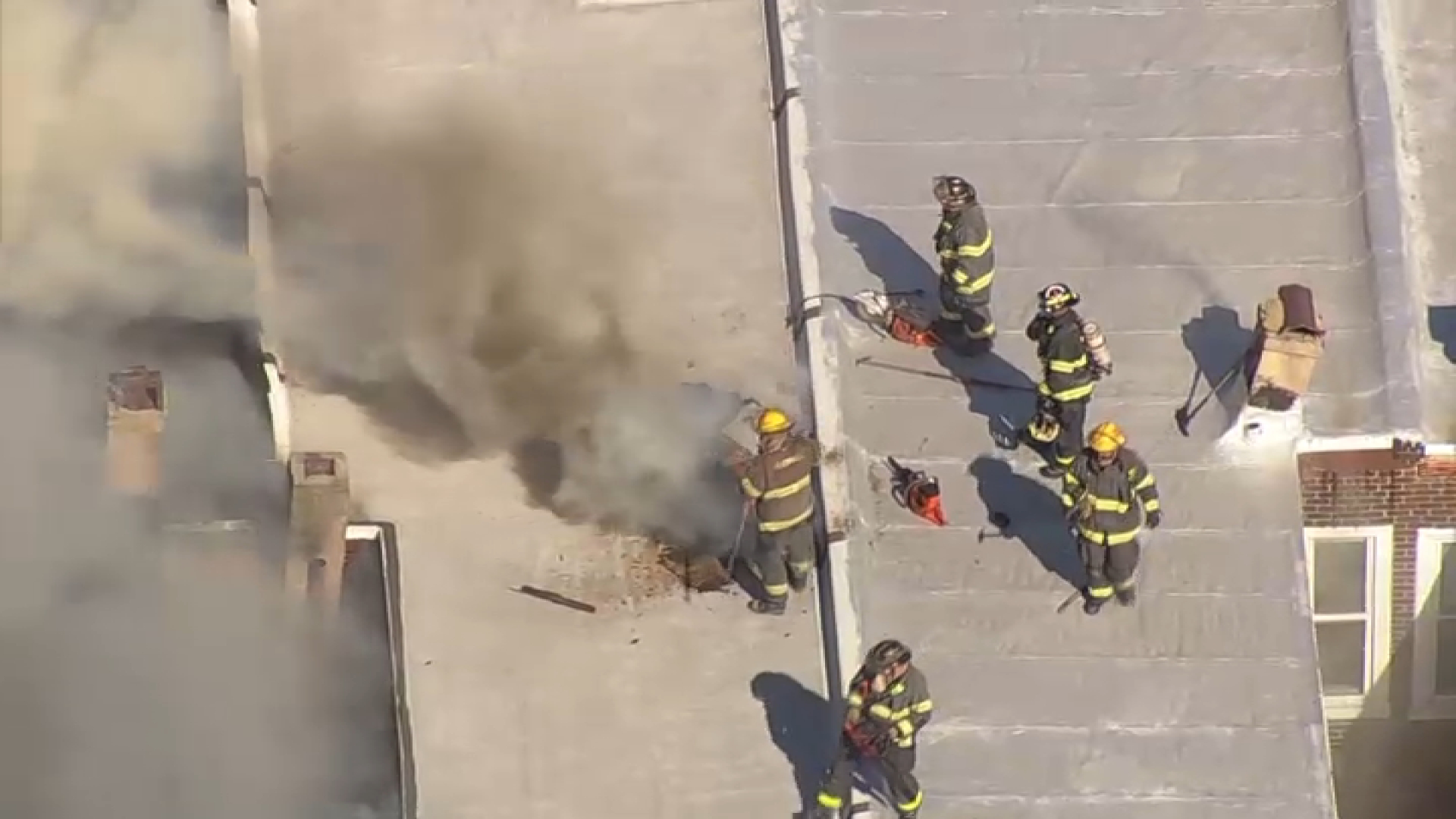 Firefighters on roof of burning rowhome on Sept. 11, 2024.