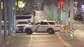 Police SUV blocking street under train tracks