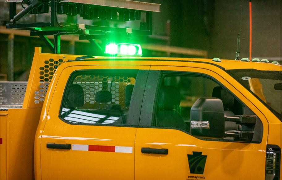 Green lights on top of yellow PennDOT truck