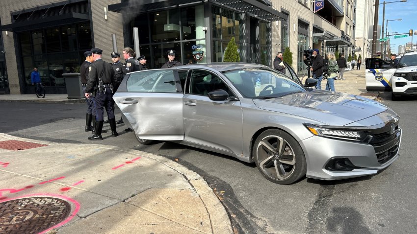 Car with damage to its side surrounded by police