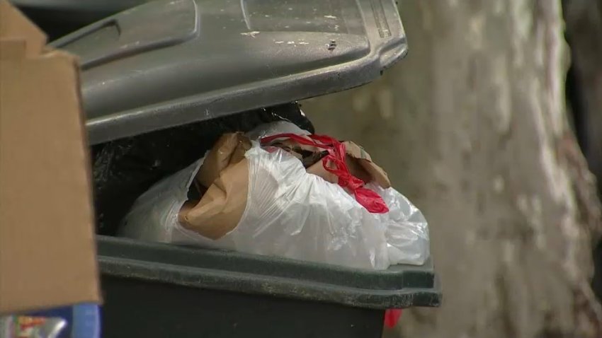 Trash bag sticking out of trash can.