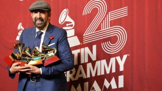 El cantante dominicano Juan Luis Guerra posa con sus premios en la alfombra roja de la 25 entrega anual de los Premios Latin Grammy.