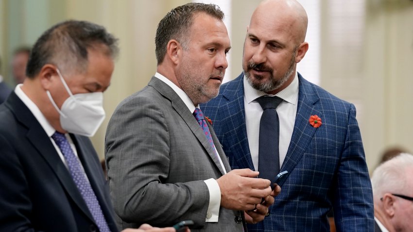 FILE -Central Valley Assembly members, Democrat Adam Gray, of Merced, center, and Republican Heath Flora of Ripon, right, confer during the Assembly session at the Capitol in Sacramento, Calif., May 27, 2022. (AP Photo/Rich Pedroncelli, File)