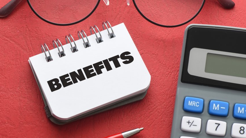 BENEFITS word in notebook on red table.