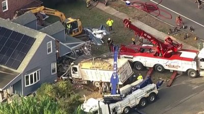Trabajadores intentan remover camión estrellado contra residencia en NJ