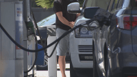 Men fill up their cars with gas at station